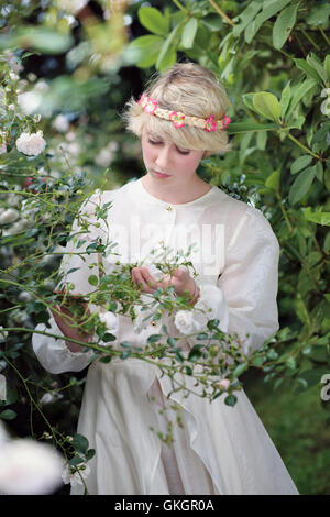 Juste jeune femme avec des roses blanches . Jardin de rêve Banque D'Images