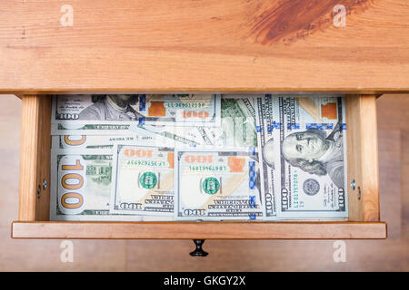 Voir ci-dessus de nombreux one hundred dollar bills sur fond de tiroir de table de nuit Banque D'Images