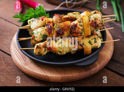 Les brochettes de poulet avec des tranches de pommes et de chili Banque D'Images