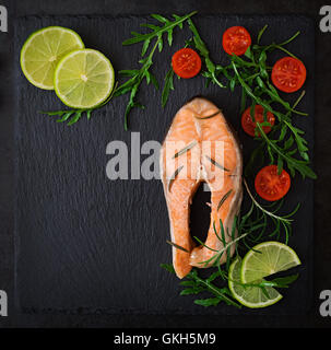 Sur le pavé de saumon cuit à la vapeur avec des légumes sur fond noir. Menu diététique. Une bonne nutrition. Vue d'en haut Banque D'Images