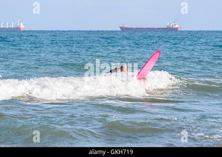 Surfer en essayant d'attraper une vague avec sa planche de surf, dans la plage de Castellon de la Plana (Espagne) Banque D'Images