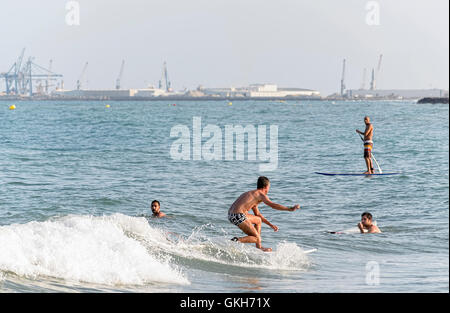 Surfer une vague avec sa planche de surf, dans la plage de Castellon de la Plana (Espagne) Banque D'Images