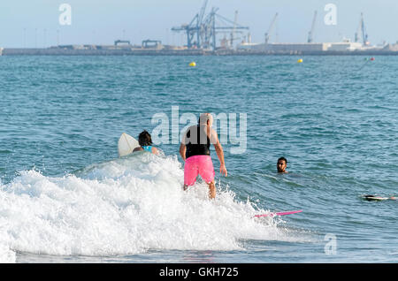 Trois surfeurs de circonscription ou d'essayer d'attraper une vague avec leurs planches, dans la plage de Castellon de la Plana (Espagne) Banque D'Images