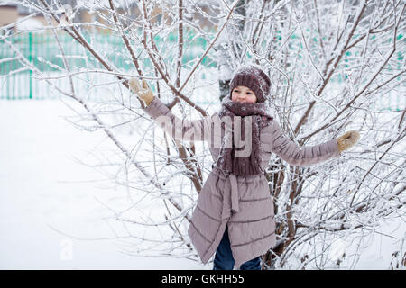 Neige, Portrait of a happy little girl sur l'arrière-plan d'un parc d'hiver Banque D'Images