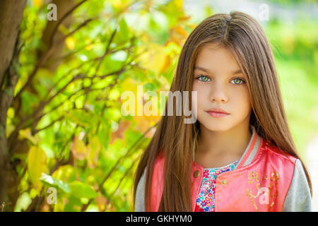 Cose, belle petite fille sur fond vert de summer city park Banque D'Images