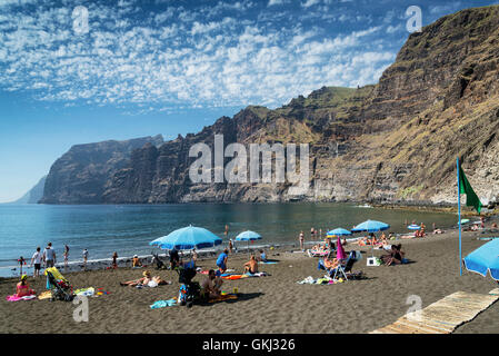 Les touristes à falaises de Los Gigantes plage de sable noir volcanique repère naturel au sud de Tenerife island espagne Banque D'Images