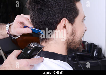 Close up of young man ayant une coupe de cheveux avec les clippers. Banque D'Images