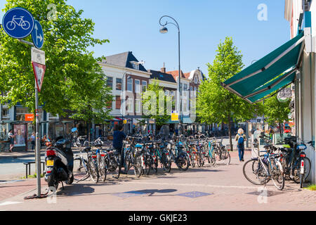 Des vélos en stationnement et les gens qui marchent sur les Gedempte Oude Gracht street dans le centre-ville de Haarlem, Pays-Bas Banque D'Images