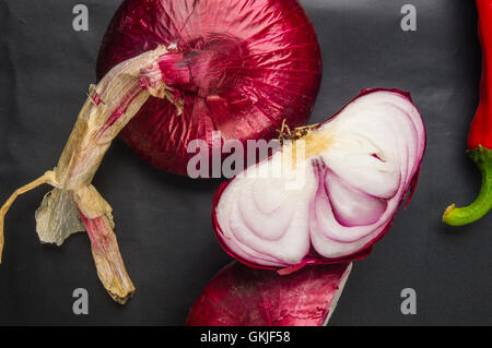 Still Life - sweet purple onion de Crimée et de Cayenne poivre rouge sur fond noir Banque D'Images