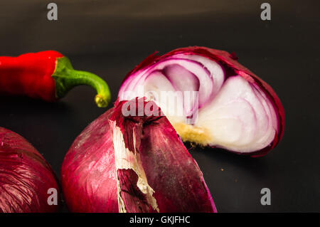 Still Life - sweet purple onion de Crimée et de Cayenne poivre rouge sur fond noir Banque D'Images