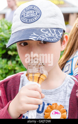 Un jeune garçon jouit d'une glace au chocolat. Banque D'Images