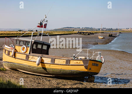 Petit bateau de pêche amarré à la jonction de Oare Creek et Faversham Creek, dans la vase à marée basse, Faversham, Kent, UK Banque D'Images