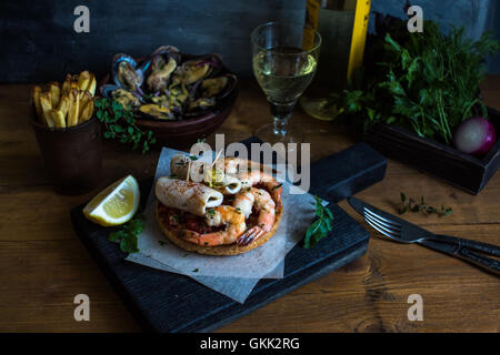 Toasts grillés avec les calmars et les crevettes. Photo sombre Banque D'Images