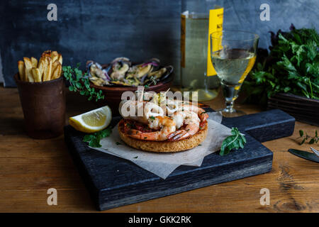 Toasts grillés avec les calmars et les crevettes. Photo sombre Banque D'Images