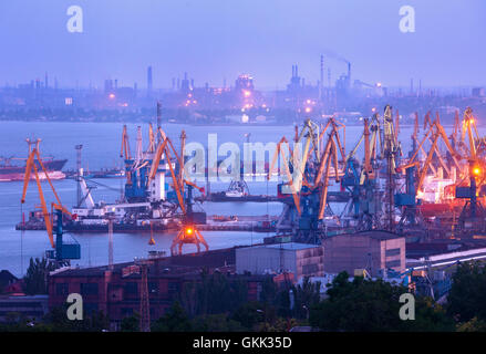 Port de commerce de la mer la nuit de travail contre l'aciérie à Mariupol, Ukraine. Paysage industriel. Fret Cargo ship Banque D'Images