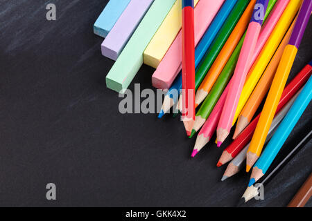 Crayons de couleur et craies sur un fond noir Banque D'Images