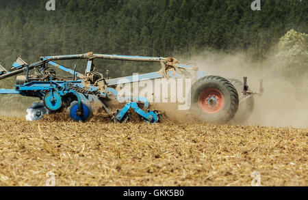 Terrain à cultiver du tracteur au printemps. Tracteur avec poignées cultivateur avant la plantation sur le terrain Banque D'Images