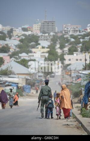 Un membre de la police somalienne marche avec son fils à Mogadiscio le 21 décembre 2015. L'image dépeint un aperçu de la vie quotidienne dans la capitale au milieu des préoccupations sécuritaires actuelles. Au un IST photo / Tobin Jones. Banque D'Images