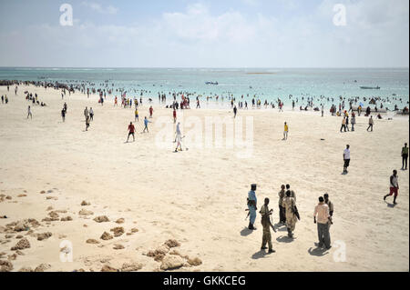 Les habitants de Mogadiscio, profitez de la plage de Lido, alors que les policiers montent la garde à l'extérieur d'un restaurant, le 31 janvier en Somalie. Les sauveteurs de Mogadishu, composé entièrement d'une armée de volontaires, des pêcheurs ont commencé à patrouiller dans la plage du Lido en septembre 2013 après une série de noyades. Les plages de Mogadiscio sont devenus une destination populaire pour les résidents de sa ville depuis al Shabab a retiré la majorité de ses militants de la ville en 2011. PHOTO ONU / UA IST Tobin Jones Banque D'Images