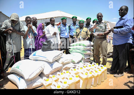 Officier de liaison humanitaire Senior, Abdul Diabagate, livre un petit discours au cours d'un document de l'alimentation à un camp de personnes déplacées, Siliga Amerikanka, le 24 février 2014. Un groupe d'agents de police individuels l'AMISOM recueillis l'argent entre eux et ont acheté des denrées alimentaires pour une communauté de 50 personnes aveugles. La communauté a reçu 10 sacs de riz, 3 sacs de maïs, 3 sacs de niébé, 3 sacs de sucre, de sel et de 20 gallons d'huile. Banque D'Images