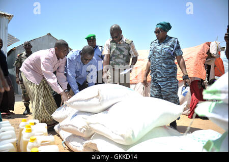 Officier de liaison humanitaire Senior, Abdul Diabagate, et vice-Supritendant Sedame Stella montrent certains des bénéficiaires d'un document où l'alimentation pour les placer dans un camp de personnes déplacées, Siliga Amerikanka, le 24 février 2014. Un groupe d'agents de police individuels l'AMISOM recueillis l'argent entre eux et ont acheté des denrées alimentaires pour une communauté de 50 personnes aveugles. Banque D'Images