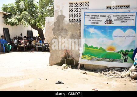 Les enfants du Somali Orphans & Disabled Homeless & Children Center étudient sous un arbre, guidés par un enseignant bénévole. Le centre offre un enseignement en études islamiques, en mathématiques et en anglais aux orphelins et aux enfants handicapés en Somalie. Banque D'Images