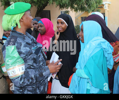 Un officier de police de l'AMISOM s'entretient avec les résidents locaux du district de Hodan à la suite d'une réunion de police communautaire dans les bureaux de district le 10 mai 2015. La réunion visait à renforcer les relations communautaires et à améliorer la coopération en matière de sécurité entre les habitants et les forces de l'ordre. Banque D'Images