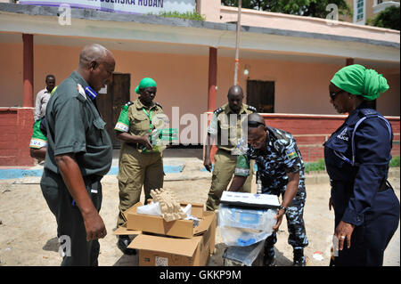 Les policiers de l'AMISOM font don de matériel de bureau, notamment un ordinateur de bureau, une imprimante et de la papeterie, au commandant du poste de police du district de Hodan, le major Hussein Mohamed Abdi, à Mogadiscio, le 15 novembre 2015. Le don soutient les opérations policières dans la région. AMISOM photo par Ilyas Ahmed. Banque D'Images