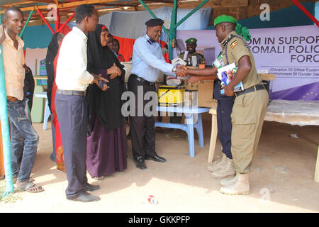Les policiers de l'AMISOM font don de matériel de bureau, notamment un ordinateur de bureau, une imprimante et de la papeterie, au commandant du poste de police du district de Baidoa, Mukhtar Ahmed Ibrahim, en Somalie, le 8 décembre 2015, dans le cadre de leur soutien aux forces de l'ordre locales. Banque D'Images