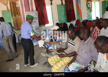 Un policier de l’AMISOM distribue des brochures aux résidents de Baidoa, en Somalie, le 8 décembre 2015, lors d’une réunion de police de proximité visant à améliorer les relations entre la police et la communauté. Banque D'Images