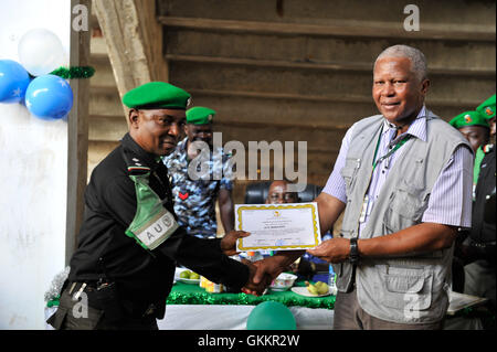 Le Major Gen. Fidza Dludlu, Chef par intérim de l’AMISOM, délivre un certificat à un policier nigérian à Mogadiscio le 26 décembre 2015. Cela a marqué l'achèvement d'un tour de service d'un an par le contingent nigérian de 140 officiers. AMISOM photo par Ilyas. Banque D'Images