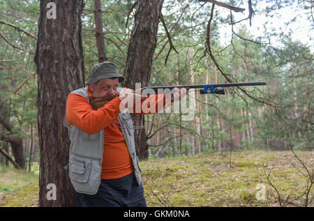 Objectif chasseur Senior fusil en forêt de pins Banque D'Images