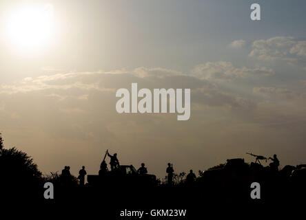 La SOMALIE, Jawahar : Dans un document de cours photographie prise le 10 décembre et publié par l'Union africaine et l'équipe de support d'information des Nations Unies 12 décembre, des soldats de l'armée nationale somalienne (SNA) sont silhouette sur le coucher de soleil dans la ville de Jawahar dans la région du Moyen-Shabelle au nord de la capitale somalienne. Mogadisu Les forces de la SNA soutenu par l'Union africaine en Somalie (AMISOM) a capturé la ville de Jawahar, 90km au nord de Mogadiscio, le 9 décembre de l'Al-Qaeda groupe extrémiste affiliés à Al Chabaab rencontrer peu de résistance alors qu'ils entraient dans l'importance économique et stratégique Banque D'Images