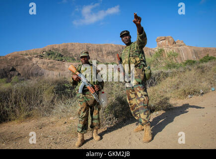 La SOMALIE, Buur-Hakba : Dans un document de cours photographie prise et publiée par l'Union africaine et l'équipe de support d'information des Nations Unies 27 février 2012, les soldats ougandais servant avec la Mission de l'Union africaine en Somalie (AMISOM) geste comme ils se tiennent dans le centre ville de Somalie. Buur-Hakba L'armée nationale somalienne (SNA) pris en charge par les forces de l'AMISOM capturé la ville d'importance stratégique sur le Afgooye-Baidoa dans le corridor de la région de la Baie d'Al-Qaeda groupe extrémiste affiliés à Al Chabaab tôt ce matin sans résistance, marquant ainsi une perte importante pour le groupe. La ville, situé à 64 kms à l'est de B Banque D'Images