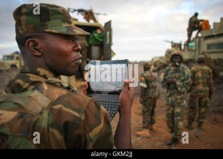 La SOMALIE, Buur-Hakba : Dans un document de cours photographie prise et publiée par l'Union africaine et l'équipe de support d'information des Nations Unies 27 février 2012, un des officiers ougandais avec l'Union africaine en Somalie (AMISOM) de films d'un ordinateur portable les préparatifs pour une avance sur la ville somalienne d'Buur-Hakba. L'armée nationale somalienne (SNA) pris en charge par les forces de l'AMISOM capturé la ville d'importance stratégique sur le Afgooye-Baidoa dans le corridor de la région de la Baie d'Al-Qaeda groupe extrémiste affiliés à Al Chabaab tôt ce matin sans résistance, marquant ainsi une perte importante pour le groupe Banque D'Images