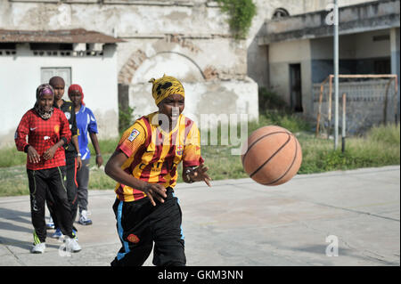 Le 6 juin, une fille passe un ballon lors d'un exercice de basket-ball à Mogadiscio, en Somalie. Après avoir été interdit par le groupe extrémiste Al Shabaab, le basket-ball regagne en popularité dans la ville. Actuellement, il y a au moins une douzaine d'équipes, avec des hommes et des femmes qui participent activement. Cette recrudescence reflète l'intérêt croissant pour les sports à Mogadiscio. Photo de Tobin Jones. Banque D'Images