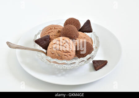 Boules de glace au chocolat et glace noisette dans un bol blanc, gros plan, macro, fond blanc, horizontal, vertical Banque D'Images