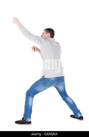Vue arrière de l'homme debout tirant une corde depuis le haut ou s'accrocher à quelque chose. guy regarder. Vue arrière Vue arrière. collection les gens de personne. Plus isolé sur fond blanc. les jambes homme tire Banque D'Images