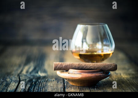 Cigare cubain dans le bac de cendres et de cognac ou de rhum Banque D'Images