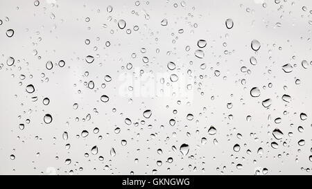 Photo de gouttes de pluie sur une vitre poussiéreuse. Banque D'Images