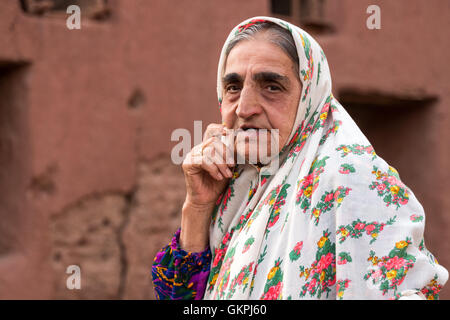 Soghra est un Abyanaki femme dont la famille a tous quitté le village. Abyaneh est un village de Barzrud District rural, dans le quartier central de comté de Natanz, Ispahan, Province de l'Iran. Au recensement de 2006, sa population était de 305 160, dans les familles.caractérisé par un étrange teinte rougeâtre, le village est un des plus anciens de l'Iran. Un Abyanaki typiquement femme porte une longue écharpe blanche (couvrant les épaules et le haut du tronc) qui a un motif coloré et d'une sous-jupe au genou. Banque D'Images