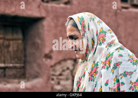 Soghra est un Abyanaki femme dont la famille a tous quitté le village. Abyaneh est un village de Barzrud District rural, dans le quartier central de comté de Natanz, Ispahan, Province de l'Iran. Au recensement de 2006, sa population était de 305 160, dans les familles.caractérisé par un étrange teinte rougeâtre, le village est un des plus anciens de l'Iran. Un Abyanaki typiquement femme porte une longue écharpe blanche (couvrant les épaules et le haut du tronc) qui a un motif coloré et d'une sous-jupe au genou. Banque D'Images