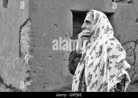 Soghra est un Abyanaki femme dont la famille a tous quitté le village. Abyaneh est un village de Barzrud District rural, dans le quartier central de comté de Natanz, Ispahan, Province de l'Iran. Au recensement de 2006, sa population était de 305 160, dans les familles.caractérisé par un étrange teinte rougeâtre, le village est un des plus anciens de l'Iran. Un Abyanaki typiquement femme porte une longue écharpe blanche (couvrant les épaules et le haut du tronc) qui a un motif coloré et d'une sous-jupe au genou. Banque D'Images