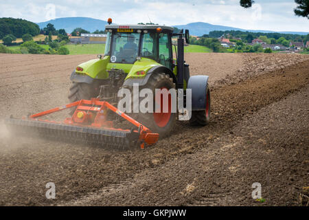 Un tracteur herse et la préparation d'un champ pour l'ensemencement dans le North Yorkshire England UK Banque D'Images