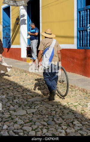 Un homme marche le long d'une rue pavée, à Trinité, la province de Sancti Spiritus, Cuba Banque D'Images