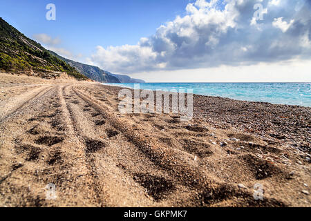 La trace d'un pneu dans le sable sur la plage Banque D'Images