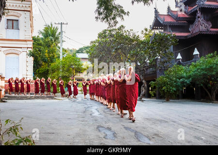 Les moines bouddhistes à l'occasion d'une soirée cérémonie de prière d'entrer au monastère Shwe Kyin au pied de Mandalay Hill, Mandalay, Myanmar (Birmanie Banque D'Images