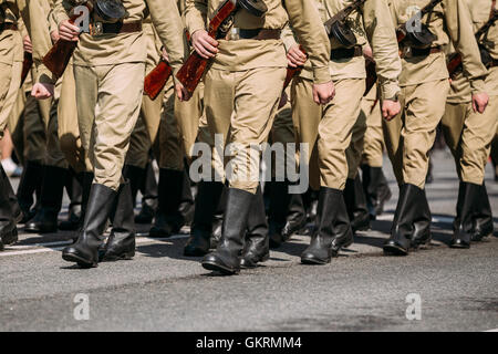 Les soldats en uniforme soviétique russe Pieds de WW2 fois en position marche sur l'asphalte. Le défilé annuel de formation de Victor Banque D'Images