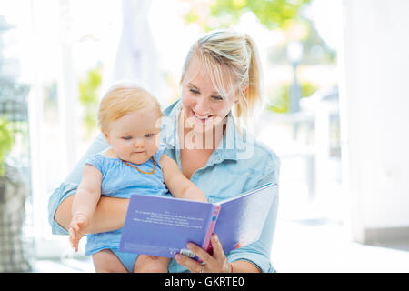 Maman lit un livre avec son bébé Banque D'Images