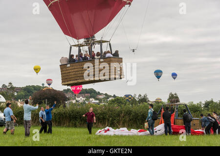 Les terres de montgolfières commerciales dans un champ à l'extérieur lors de la 38e conférence annuelle de Bristol Bristol International Balloon Fiesta Banque D'Images